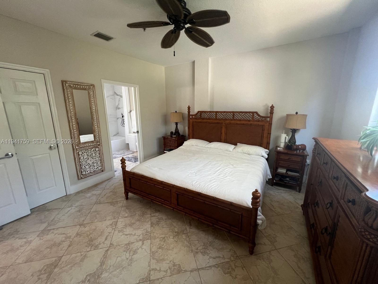 75 Gulfstream Road, Unit 211B Dania Beach, FL 33004 - Photo 12 of 57 a bed room with a bed and a chandelier
