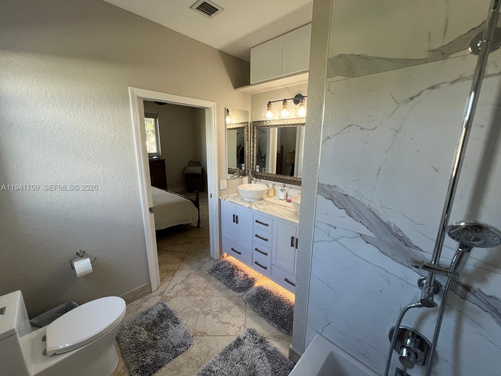 75 Gulfstream Road, Unit 211B Dania Beach, FL 33004 - Photo 16 of 57 a bathroom with a sink toilet and mirror