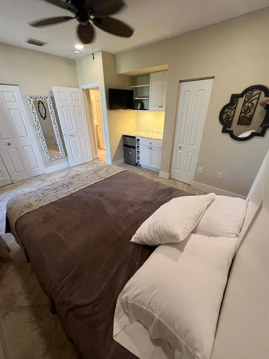 75 Gulfstream Road, Unit 211B Dania Beach, FL 33004 - Photo 32 of 57 a bedroom with a bed and a walk in closet