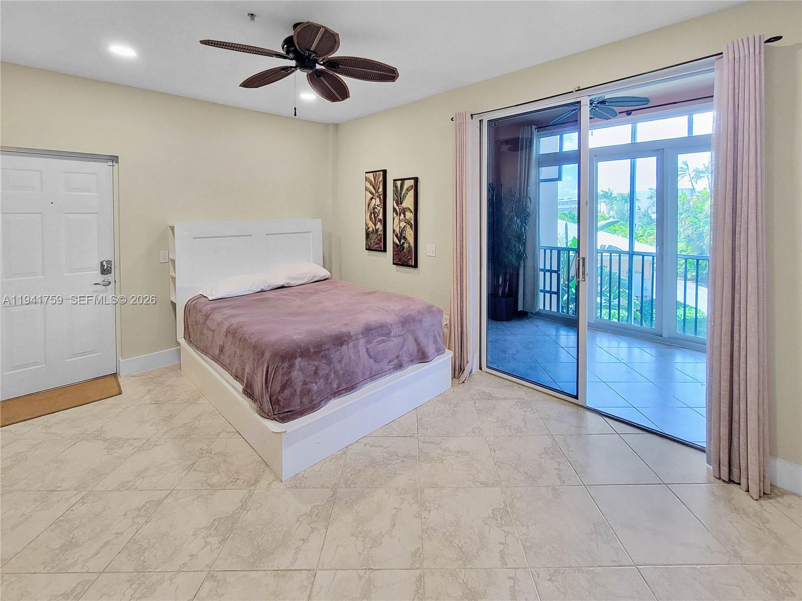 75 Gulfstream Road, Unit 211B Dania Beach, FL 33004 - Photo 54 of 57 a spacious bedroom with a large bed and a chandelier fan