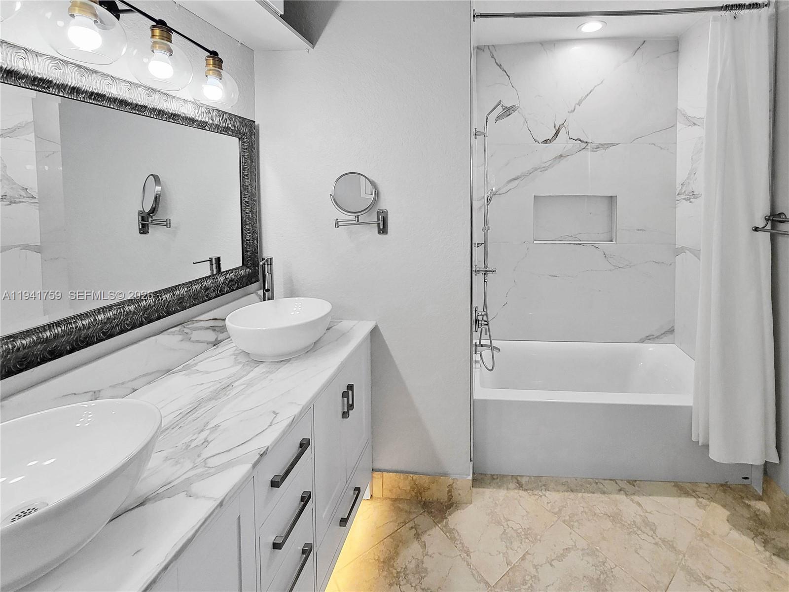 75 Gulfstream Road, Unit 211B Dania Beach, FL 33004 - Photo 55 of 57 a bathroom with a granite countertop sink a mirror and a bathtub