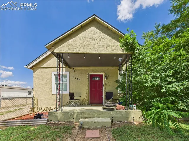 a view of a house with backyard and trees