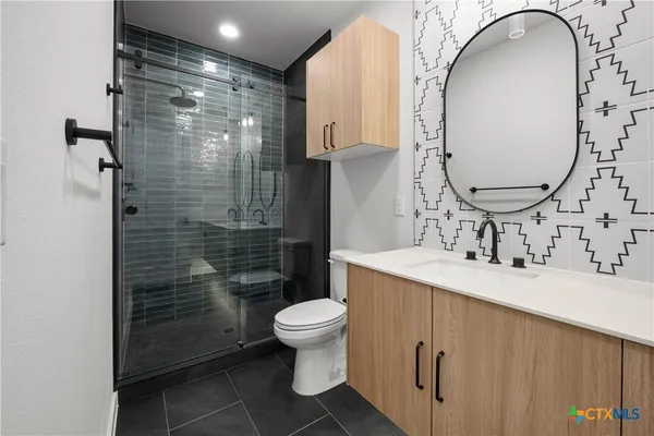 a bathroom with a sink a toilet and shower
