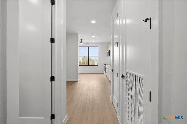 a view of a hallway with wooden floor
