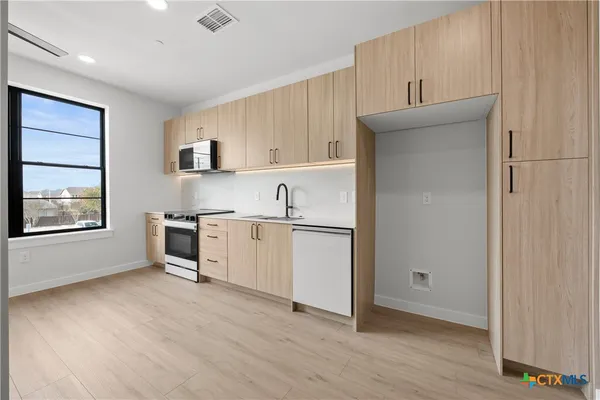 a kitchen with granite countertop white cabinets and white appliances