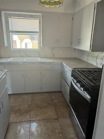 a kitchen with a stove a sink and a window
