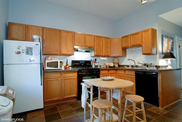 a kitchen with a refrigerator a stove a sink and white cabinets