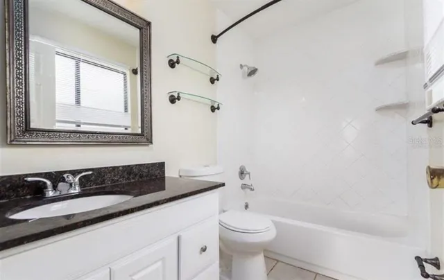a bathroom with a bathtub sink vanity mirror and toilet