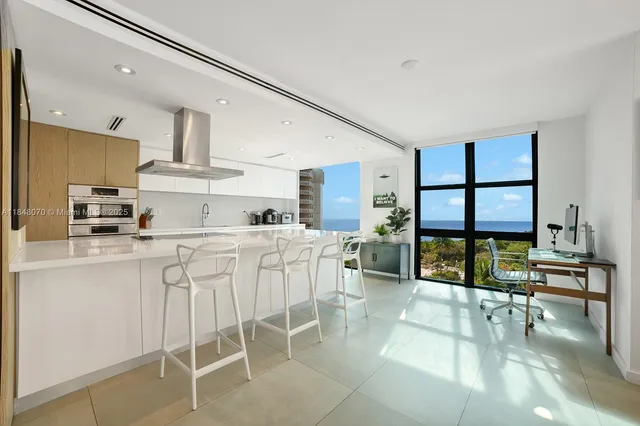 a kitchen with white cabinets and chairs