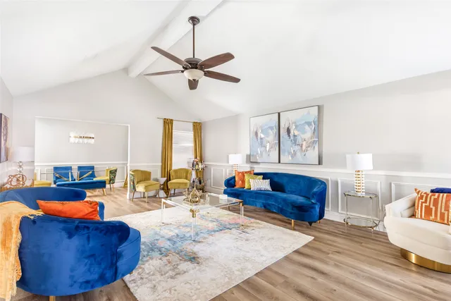 a living room with furniture kitchen view and a window