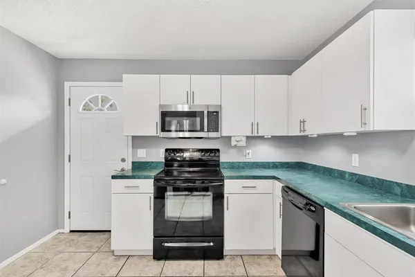 a kitchen with white cabinets stainless steel appliances and sink