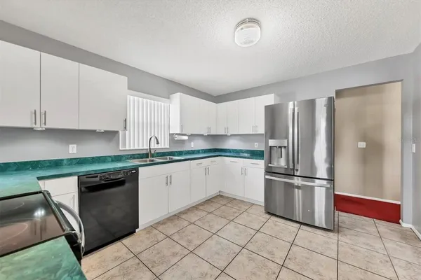 a kitchen with granite countertop a refrigerator and a stove top oven