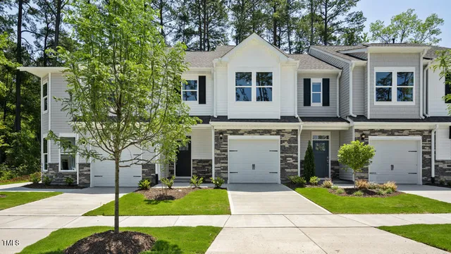 a view of a white house with a yard and large tree