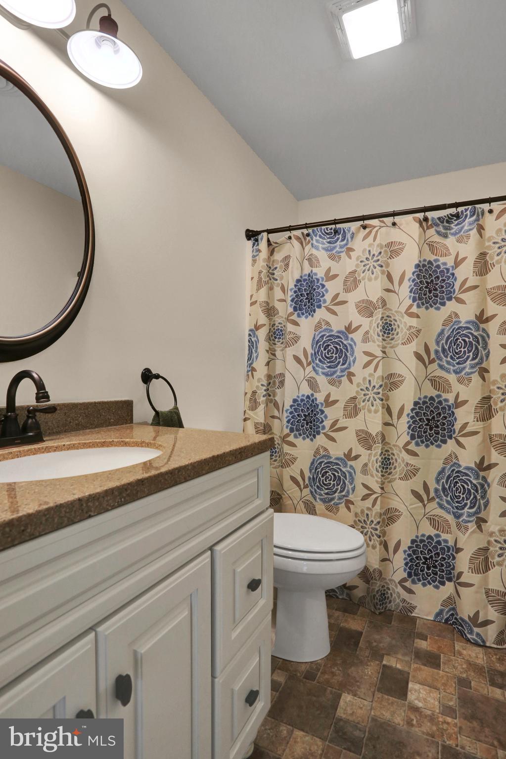 14809 Clear Spring Road Williamsport, MD 21795 - Photo 16 of 27 a bathroom with a granite countertop sink a toilet and a mirror