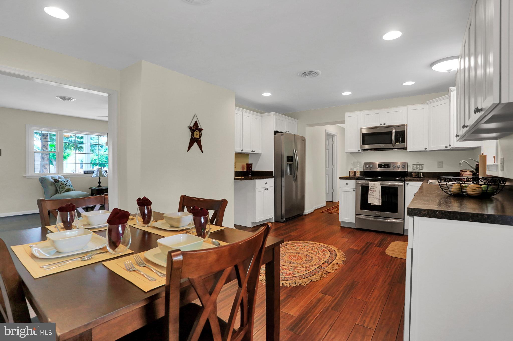 14809 Clear Spring Road Williamsport, MD 21795 - Photo 4 of 27 a kitchen with stainless steel appliances granite countertop a refrigerator a stove top oven a sink dishwasher and white cabinets with wooden floor