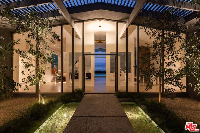 a view of a porch with a table and chairs next to a yard