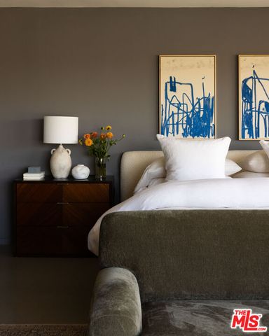 a bedroom with a large window and a bed