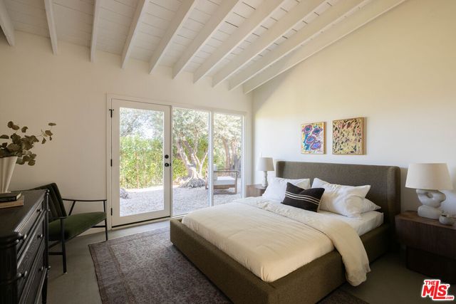 a bedroom with a bed and a large window