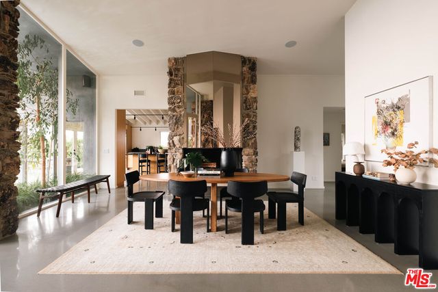 a living room with couches a table and chairs with wooden floor