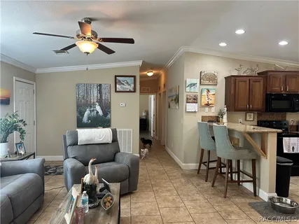 a living room with furniture kitchen view and a wooden floor