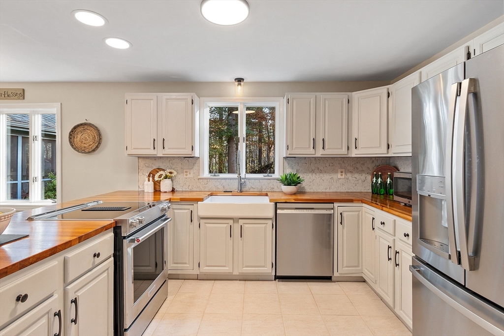 26 Bayberry Road Groton, MA 01450 - Photo 5 of 34 a kitchen with a sink dishwasher a stove and white cabinets with wooden floor
