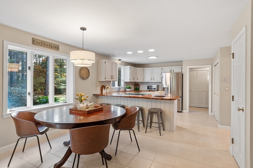 26 Bayberry Road Groton, MA 01450 - Photo 7 of 34 a kitchen with a dining table chairs and white cabinets