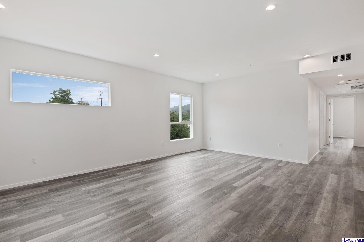 7064 Greeley Street, Unit 203 Tujunga, CA 91042 - Photo 17 of 42 a view of an empty room with wooden floor and a window