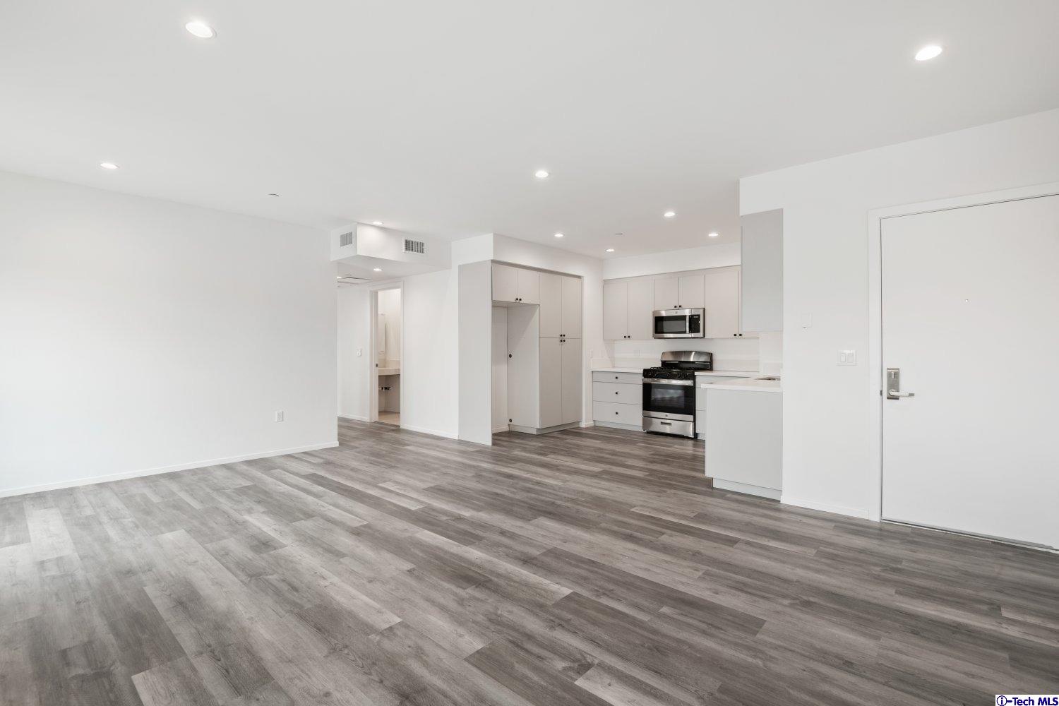 7064 Greeley Street, Unit 203 Tujunga, CA 91042 - Photo 18 of 42 a view of kitchen and empty room with wooden floor