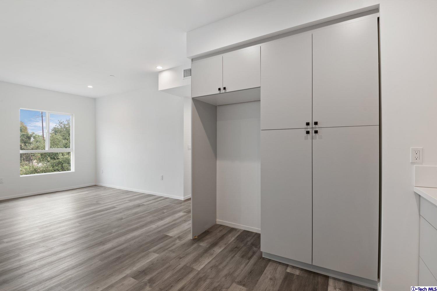 7064 Greeley Street, Unit 203 Tujunga, CA 91042 - Photo 23 of 42 a view of an empty room with wooden floor and a window