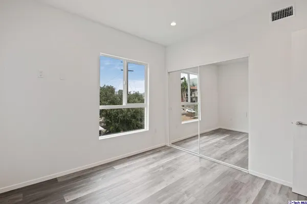 an empty room with wooden floor and white walls