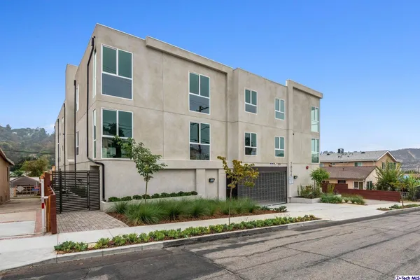 a front view of a house with a yard and potted plants