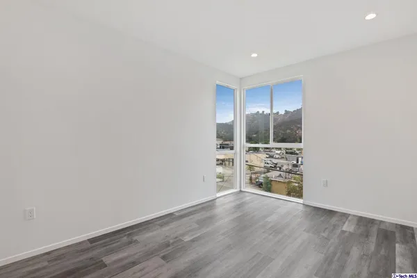 a view of empty room with wooden floor