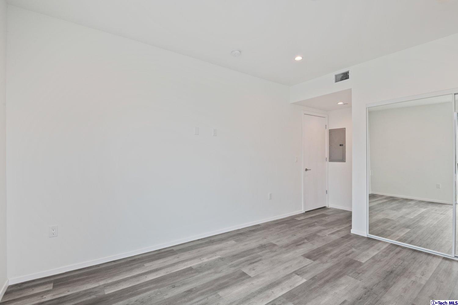 7064 Greeley Street, Unit 203 Tujunga, CA 91042 - Photo 33 of 42 an empty room with wooden floor and white walls