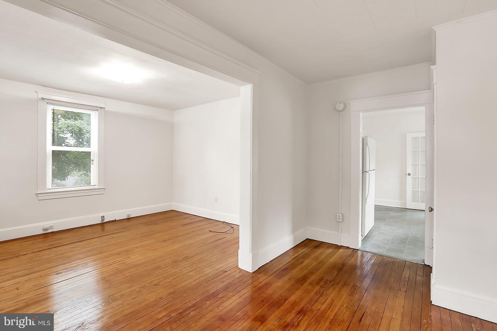 3525 St James Road Windsor Mill, MD 21244 - Photo 3 of 27 an empty room with wooden floor and windows