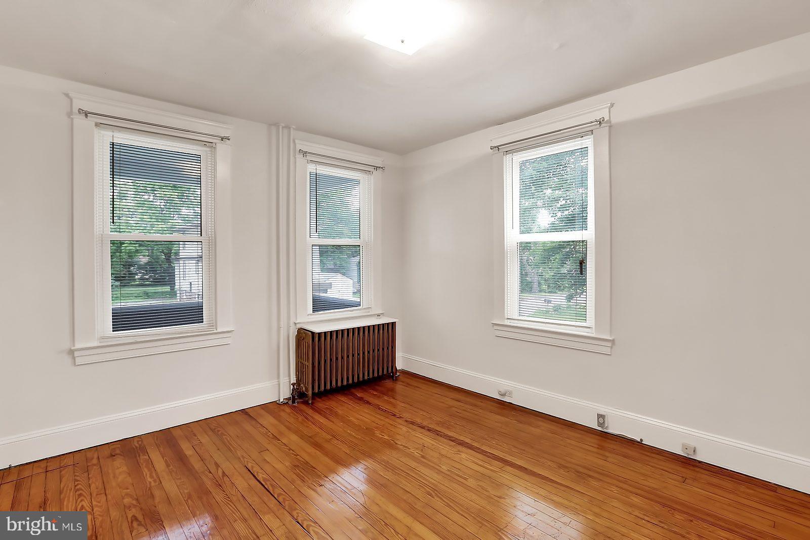 3525 St James Road Windsor Mill, MD 21244 - Photo 4 of 27 an empty room with wooden floor and windows