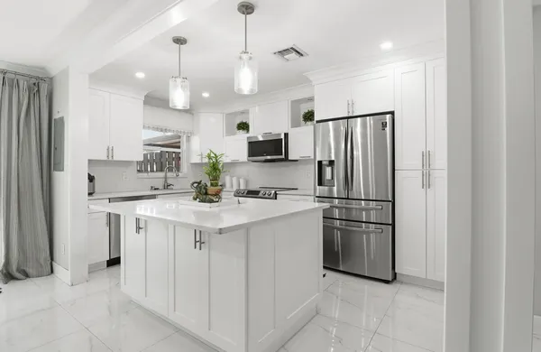 a kitchen with kitchen island a sink stainless steel appliances and cabinets