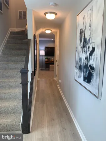 a view of a hallway with wooden floor and staircase