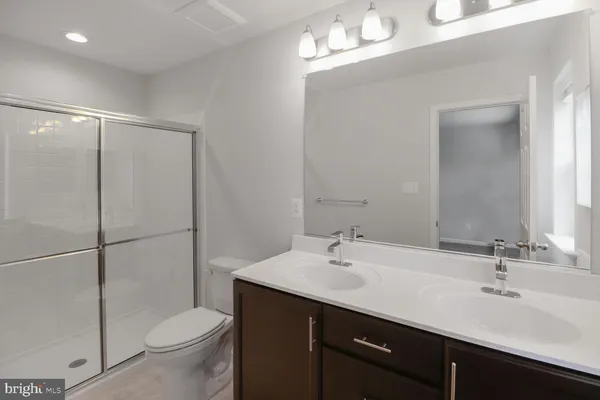 a bathroom with a double vanity sink toilet and a mirror