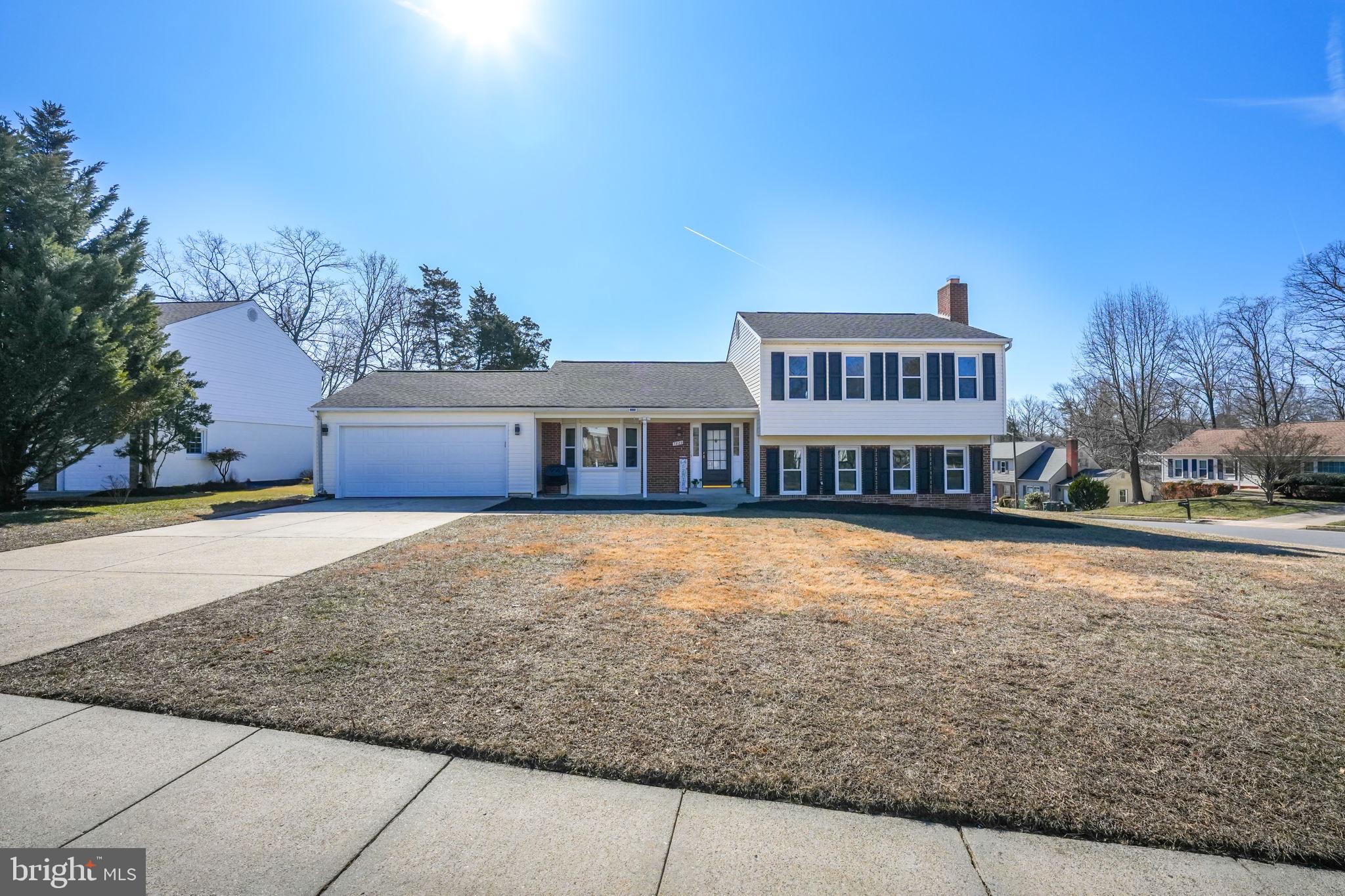 a front view of a house with a yard and tree s