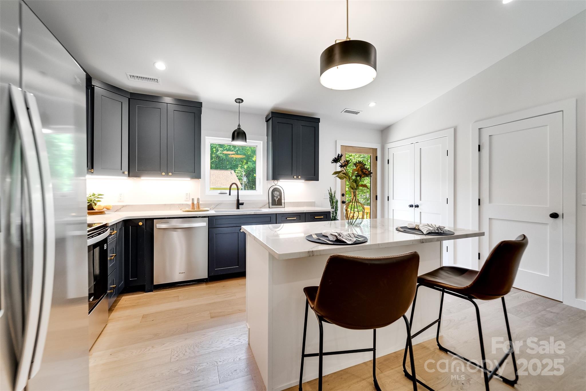 22 Crossing Lane Sylva, NC 28779 - Photo 11 of 44 a kitchen with stainless steel appliances kitchen island granite countertop a sink a stove a refrigerator and island with wooden floor