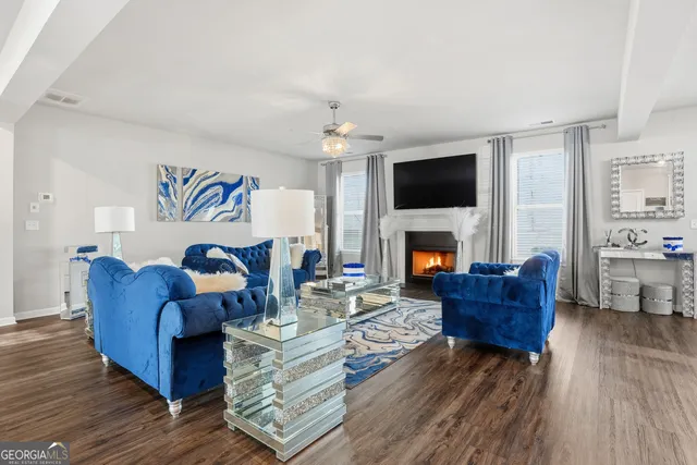 a living room with stainless steel appliances kitchen island granite countertop furniture wooden floor and a view of kitchen