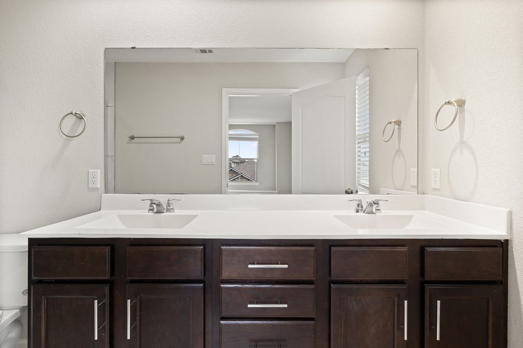 719 Coconut Grove Street Pflugerville, TX 78660 - Photo 26 of 31 a bathroom with a sink vanity and a mirror
