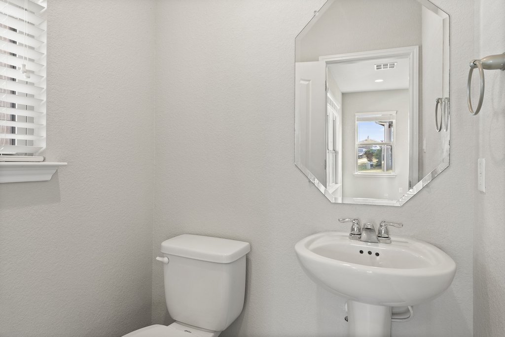 719 Coconut Grove Street Pflugerville, TX 78660 - Photo 27 of 31 a bathroom with a toilet sink and mirror