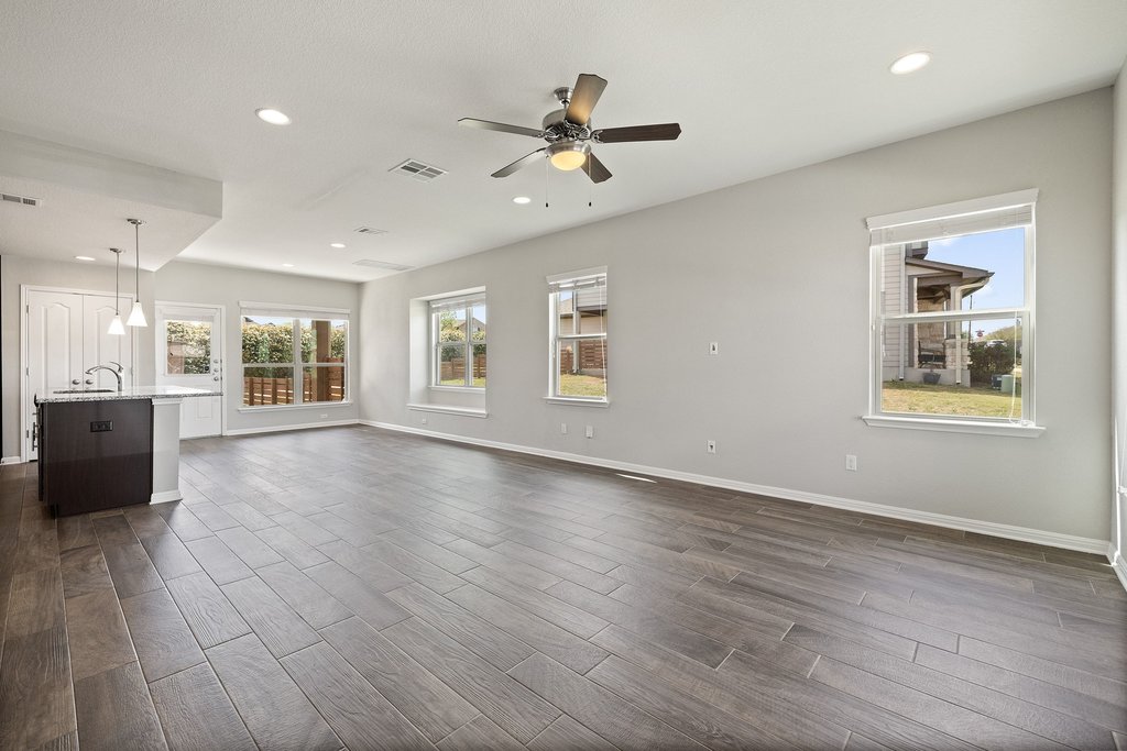 719 Coconut Grove Street Pflugerville, TX 78660 - Photo 4 of 31 a view of an empty room with a window and wooden floor