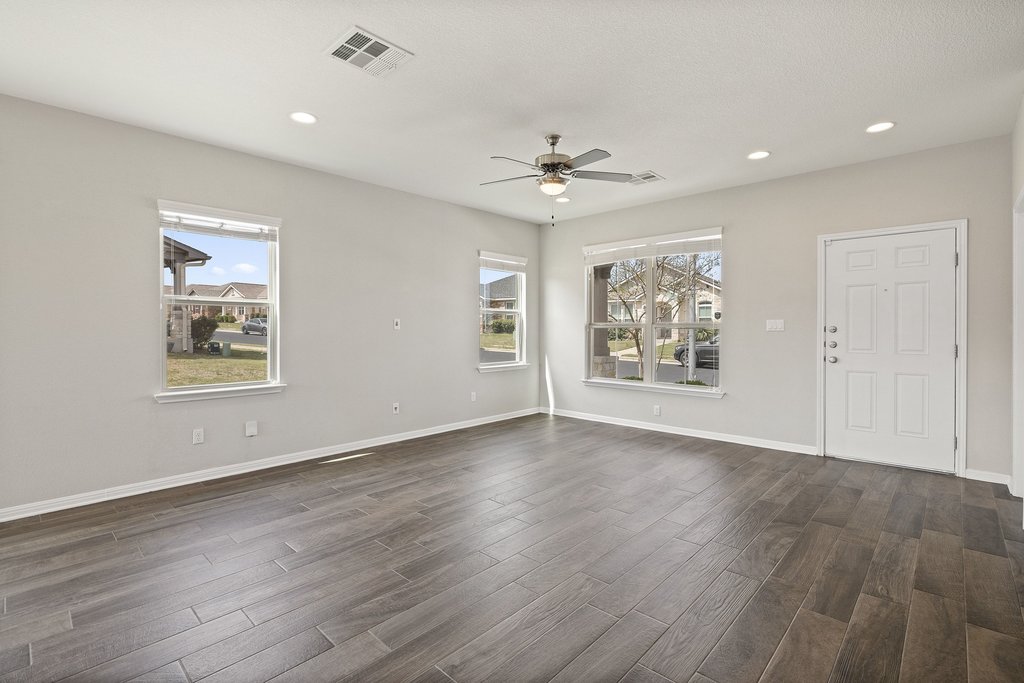719 Coconut Grove Street Pflugerville, TX 78660 - Photo 8 of 31 a view of an empty room with a window and wooden floor