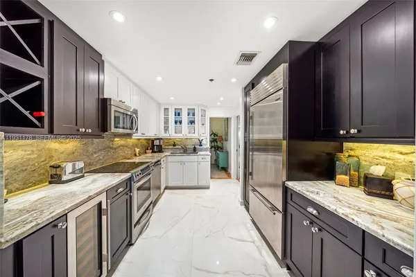 a kitchen with granite countertop a sink a counter top space appliances and cabinets