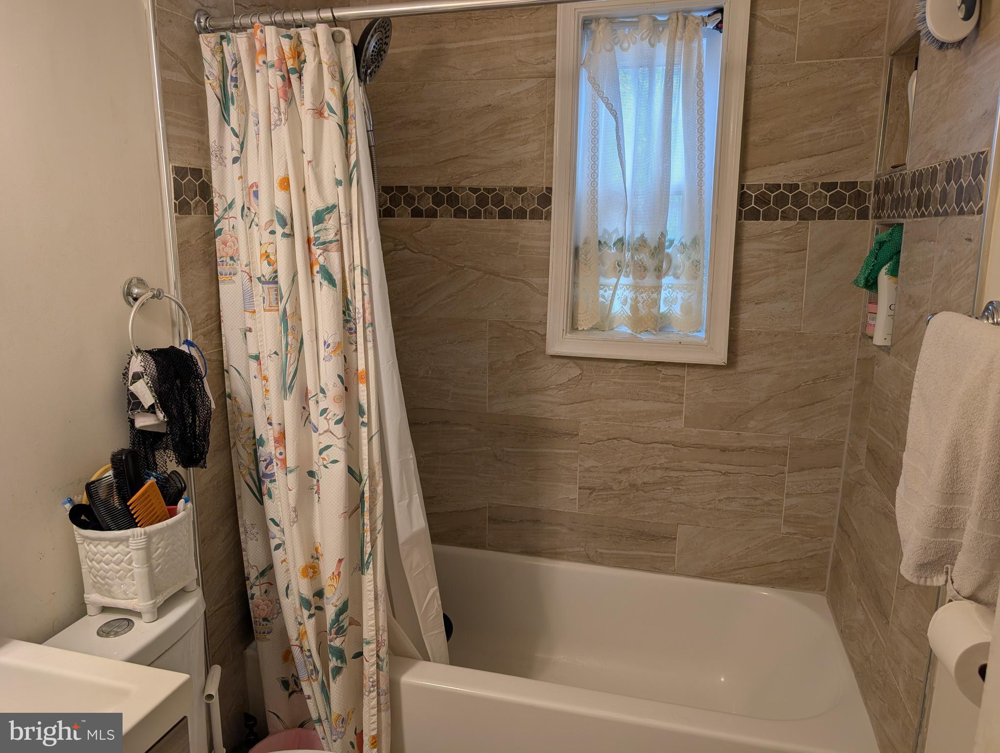 12816 Valleywood Drive Silver Spring, MD 20906 - Photo 15 of 20 a bathroom with a shower curtain and a bathtub