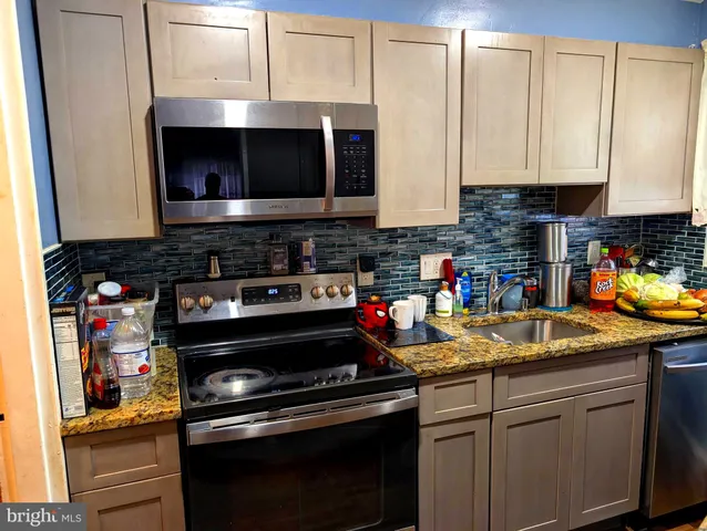 a kitchen with stainless steel appliances granite countertop a stove and a microwave