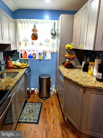 a kitchen with a stove and a white wooden cabinets