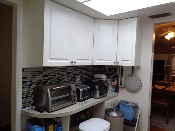 a kitchen with a sink and a stove with white countertops